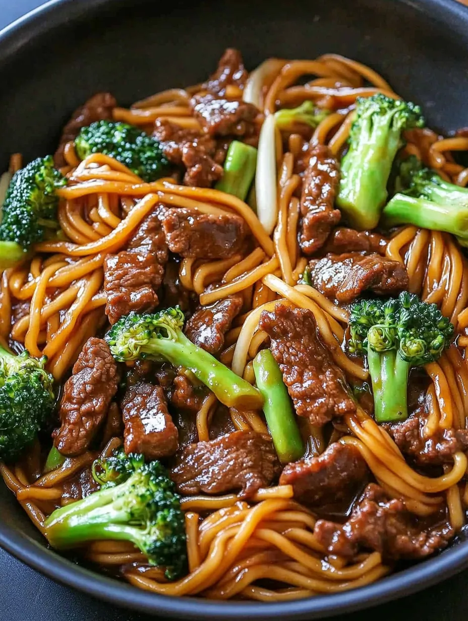 A bowl of noodles with meat and broccoli.