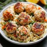 A bowl of pasta with meatballs and vegetables.