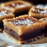 A plate of desserts, including a piece of cake and a brownie, is presented on a white plate.