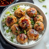 A bowl of meatballs and rice.