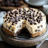 A slice of chocolate cake with chocolate chips on top.